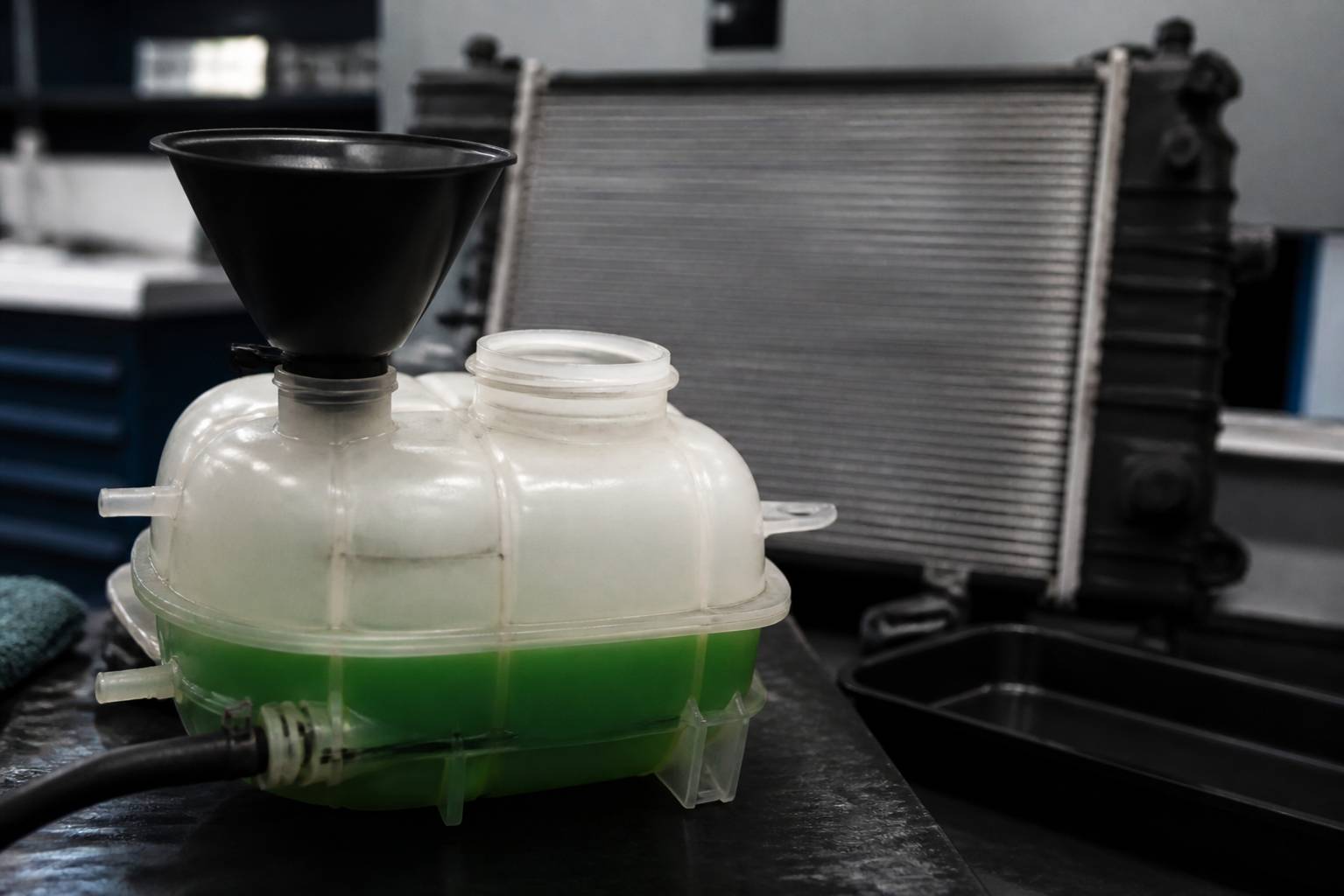 Bocal de liquide coloré ouvert avec entonnoir près du radiateur